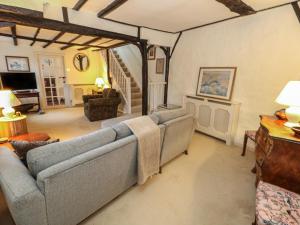 a living room with two couches and a staircase at Poppy Cottage in Beaminster