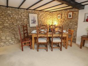a dining room with a wooden table and chairs at Poppy Cottage in Beaminster +21 photos