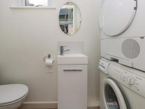 ein Badezimmer mit Waschmaschine und Waschbecken in der Unterkunft Poppy Cottage in Beaminster + 21 Fotos