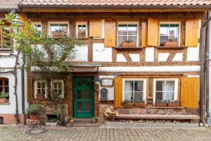 an old wooden house with a green door and windows at Schwarzwaldstübchen nähe Europapark in Ettenheim