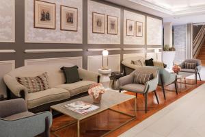 a living room with couches and chairs and a table at Catalonia Las Cortes in Madrid