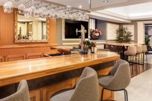 a restaurant with a bar with chairs and a mirror at Catalonia Las Cortes in Madrid