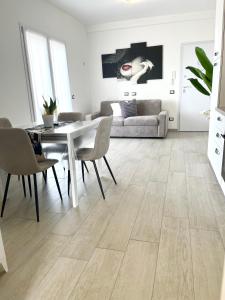 a living room with a table and chairs and a couch at MaurusHome come a casa tua. in Fiumicino +13 photos