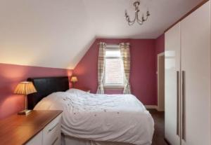1 dormitorio con cama blanca y ventana en Hillhouse Blackhall en Edimburgo