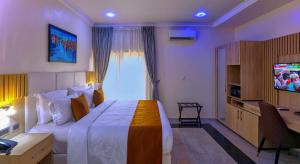 a hotel room with a large bed and a television at Hamasville Boutique Hotel in Abuja