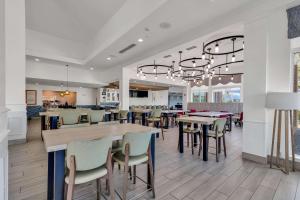 un comedor con mesas y sillas en un restaurante en Hilton Garden Inn Myrtle Beach/Coastal Grand Mall en Myrtle Beach