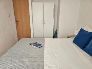 a bedroom with a bed with a book on it at Apartman Sara-Vis in Vis