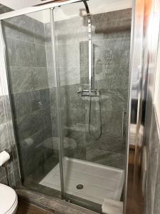 y baño con ducha y puerta de cristal. en Saturno house Cagliari Center, en Cagliari