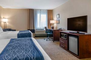 a hotel room with two beds and a flat screen tv at Comfort Inn Bozeman near University in Bozeman