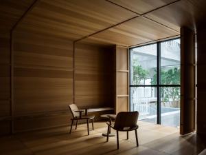 une chambre avec deux chaises, une table et une fenêtre dans l'établissement SHIROIYA HOTEL, à Maebashi