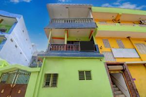 een geel en groen gebouw met een balkon bij Goroomgo Sri Ram Guest House Puri in Puri