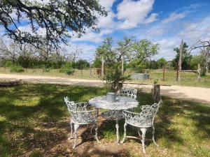 a table and four chairs sitting in a field at Cabin in the Woods under the Stars with HOT TUB in Bandera