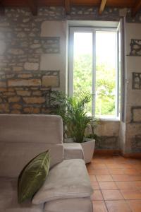 ein Wohnzimmer mit einem Sofa und einem Fenster in der Unterkunft Domaine de KIBA - Maison de Maitre in Barzan