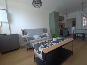 a living room with a couch and a table at L'olivier Maison de ville proche Cabourg in Dozulé