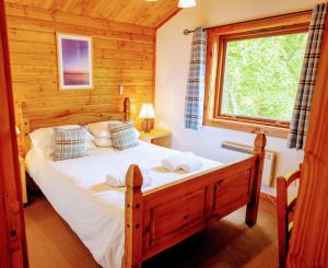 a bedroom with a bed in a log cabin at Loch Insh Chalets Ltd in Kincraig
