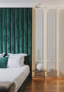 um quarto com uma parede verde com uma cama e uma mesa em Hôtel Singulier Bordeaux em Bordeaux