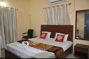 a hotel room with a bed with a mirror and a mirror at Goroomgo Green Akress Bhubaneswar in Bhubaneshwar