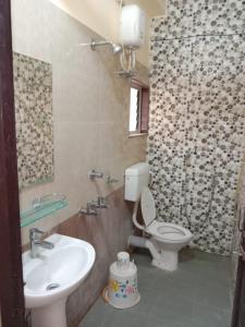a bathroom with a toilet and a sink at Goroomgo Green Akress Bhubaneswar in Bhubaneshwar