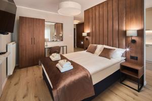 a bedroom with a large bed with two towels on it at Symphony City Square Aparthotel in Wrocław +209 photos