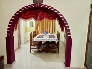 ein Esszimmer mit einem Torbogen mit einem Tisch und Stühlen in der Unterkunft soms estate stay in Madikeri