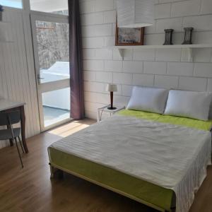 een slaapkamer met een bed in een kamer met een balkon bij Le Jardin De Nicolas in Couret