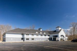 ein großes weißes Gebäude mit Parkplatz in der Unterkunft Quality Inn in Carrollton