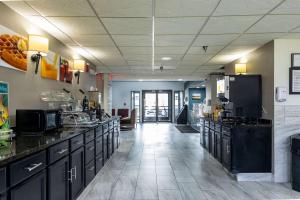 een grote keuken met zwarte werkbladen in een kamer bij Quality Inn in Carrollton