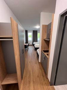 a room with a hallway with a kitchen and a living room at Firstsleep Ebersberg in Ebersberg
