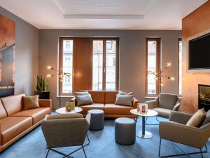 a living room with couches and chairs and a tv at ibis Styles Bamberg in Bamberg