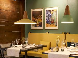 una sala da pranzo con due tavoli, sedie e luci di Hotel Schnitterhof a Bad Sassendorf
