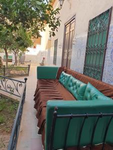 een groene bank buiten een gebouw bij Riad Elaissi in Taroudant