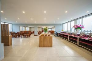 a restaurant with tables and chairs and windows at Tahiti Central Seaview - 50m to Night Market Phu Quoc in Phú Quốc