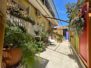 un callejón con macetas al lado de un edificio en La Casa di Via Nervi, en Ladispoli