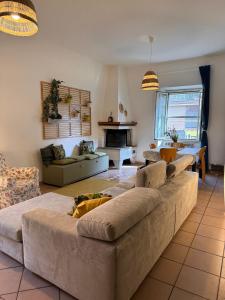 una sala de estar con un sofá grande en el centro en La Casa di Via Nervi, en Ladispoli