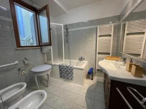 y baño con lavabo, bañera y aseo. en La Casa di Via Nervi, en Ladispoli