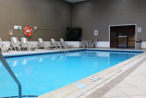 北普拉特的住宿－Ramada by Wyndham North Platte，一个带桌椅的大型游泳池