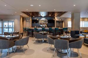 um restaurante com mesas e cadeiras e um bar em Cambria Hotel Minneapolis Downtown em Minneapolis