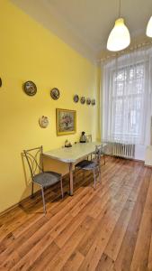 une salle à manger avec une table et des chaises et des murs jaunes dans l'établissement Kamil Apartments, Delux A, 65m2, à Karlovy Vary