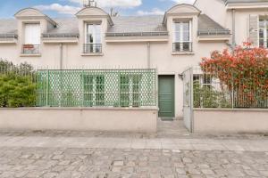 une maison avec une porte verte et une clôture dans l'établissement Maison avec terrasse privée, à Versailles
