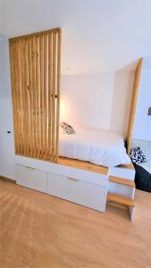 a bedroom with a bed with a wooden headboard at Appartement AX - proche départ rando - piscine - balcon - Le blancflocon in Ax-les-Thermes