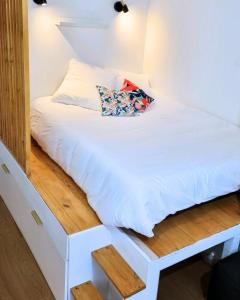 a white bed with a pillow on top of it at Appartement AX - proche départ rando - piscine - balcon - Le blancflocon in Ax-les-Thermes