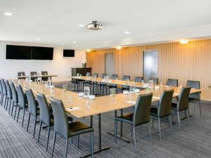 una gran sala de conferencias con una mesa larga y sillas en Mantra Melbourne Melton, en Melton