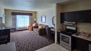 a living room with a kitchen and a living room with a couch at Comfort Inn & Suites in Beeville