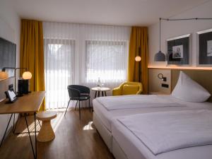 ein Hotelzimmer mit einem Bett und einem Tisch und Stühlen in der Unterkunft Hotel Schnitterhof in Bad Sassendorf