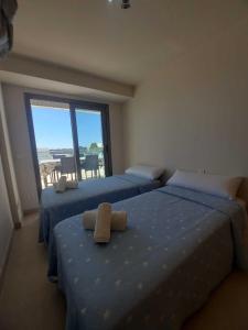 1 dormitorio con 2 camas y ventana con vistas en La Perla Verde apartment on Aguilón GolfPulpí, en Pilar de Jaravía