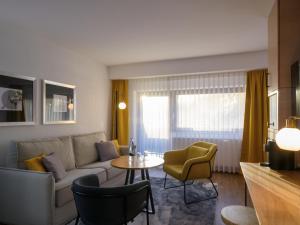 Hotel Schnitterhof في باد ساسيندورف: غرفة معيشة مع أريكة وطاولة وكراسي