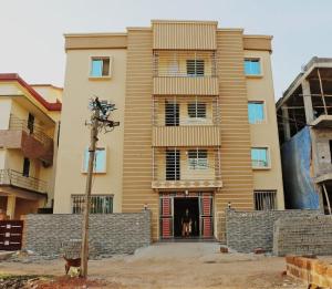 a man standing in the doorway of a building at Goroomgo Green Akress Bhubaneswar in Bhubaneshwar