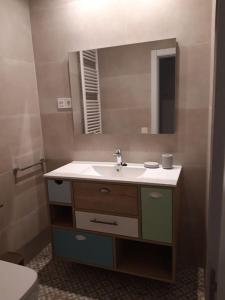 un baño con lavabo y espejo en Rincón en edificio Modernista en centro de Soria, en Soria
