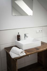 ノルデンにあるWattlodgeのバスルーム(白い洗面台、鏡付)