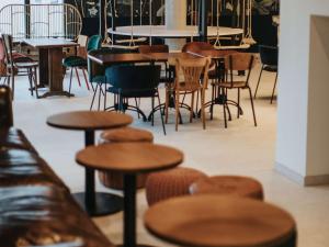 un groupe de tables et de chaises dans un restaurant dans l'établissement Greet Hotel Brest Aéroport, à Guipavas